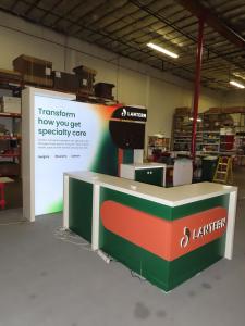 Custom Inline with SuperNova Backlit Fabric Graphic, Wood Frame, Monitor Mount with Graphic Support Panels, Backlit Logos, Backwall Counter with RGB LED Accent Lights, and L-Shaped Counter with Backlit Logo, RGB LED Accent Lights, and Locking Storage